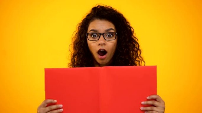 聪明的混血儿女性千禧一代震惊于科学事实，拿着红皮书