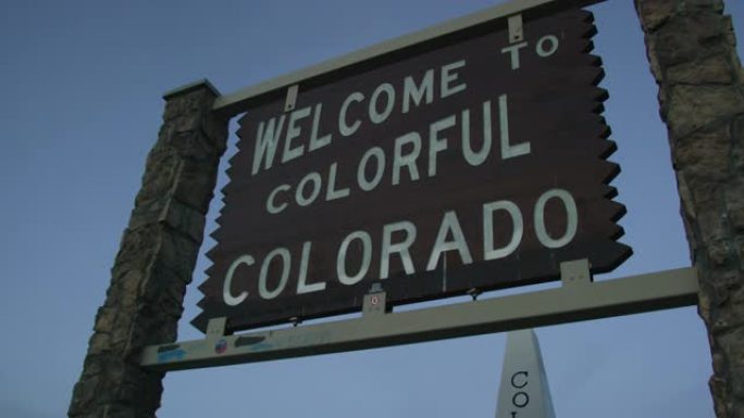 日落时，车辆在70号州际公路上的科罗拉多州/犹他州边界上的 “欢迎来到色彩缤纷的科罗拉多州” 州线标