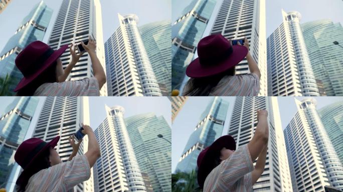 年轻的游客在新加坡城市用智能手机拍照