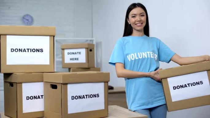 年轻的微笑活动家手持捐款箱，志愿服务中心，慈善事业