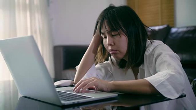 压力过大的年轻女子，手提电脑在家工作