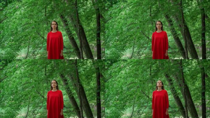 站在森林里的穿着红色连衣裙的女人
