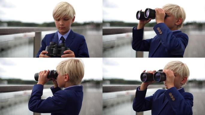 年轻的男生通过双筒望远镜在栏杆上寻找