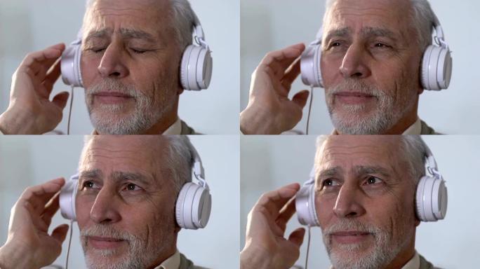 忧郁的老人戴着耳机听音乐，回忆青春，怀旧