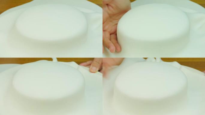 在蛋糕上盖上卷好的白软糖。前视图。