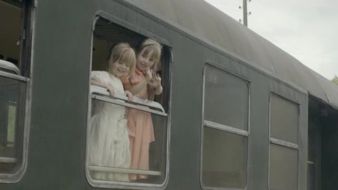 女孩从旧的蒸汽火车车厢里挥手