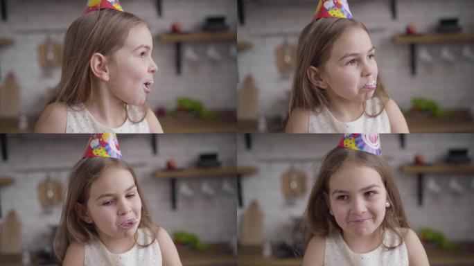 Slowmo，快乐的高加索黑发女孩的特写肖像，脸上脏了糖果咀嚼蛋糕。快乐的棕色眼睛的小孩在生日聚会上
