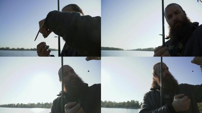 渔夫在钩子上放了一条虫子，并在上面指着。正在钓鱼的成年男子的肖像。河流捕鱼。在河上钓鱼。