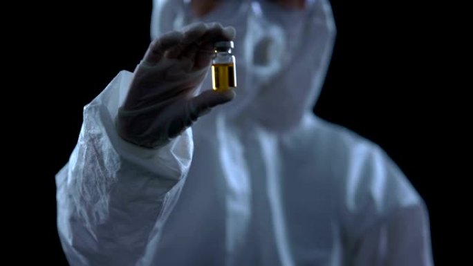 流行病学家显示带有黄色液体的瓶子，疫苗开发，治疗