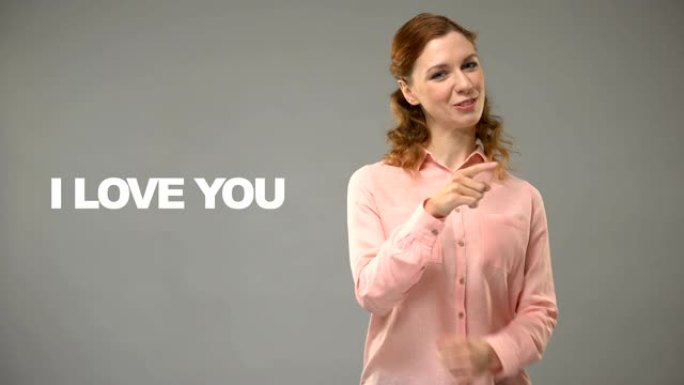 聋人女人用手语说爱你，背景交流上的文字