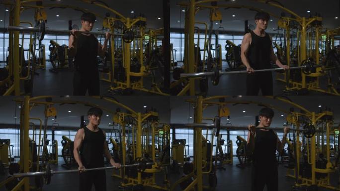 4k慢动作亚洲男子在健身房锻炼，举重强壮男子做杠铃，在铁杆健身房锻炼。肌肉和运动健美运动员