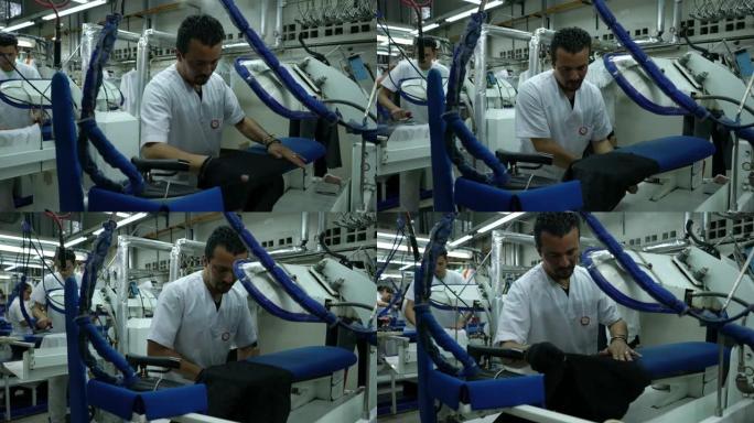 熟练的男性员工在洗衣店熨衣服