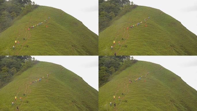 一群旅行者在雨天走在草山上