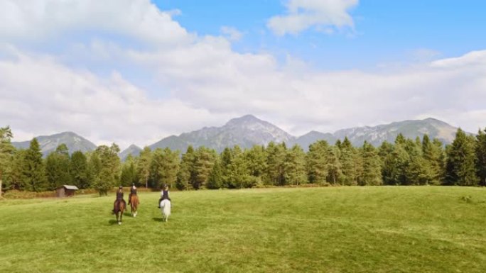 三人骑马穿越草地的空中镜头