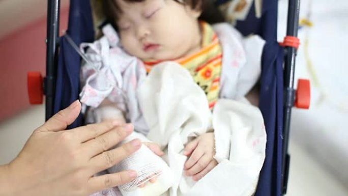 生病的婴儿在医院的安全座椅上接受生理盐水
