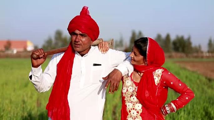 印度农民与妻子站在田间