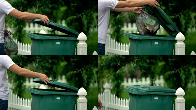 男市民往垃圾桶扔垃圾，防止乱丢垃圾，环境