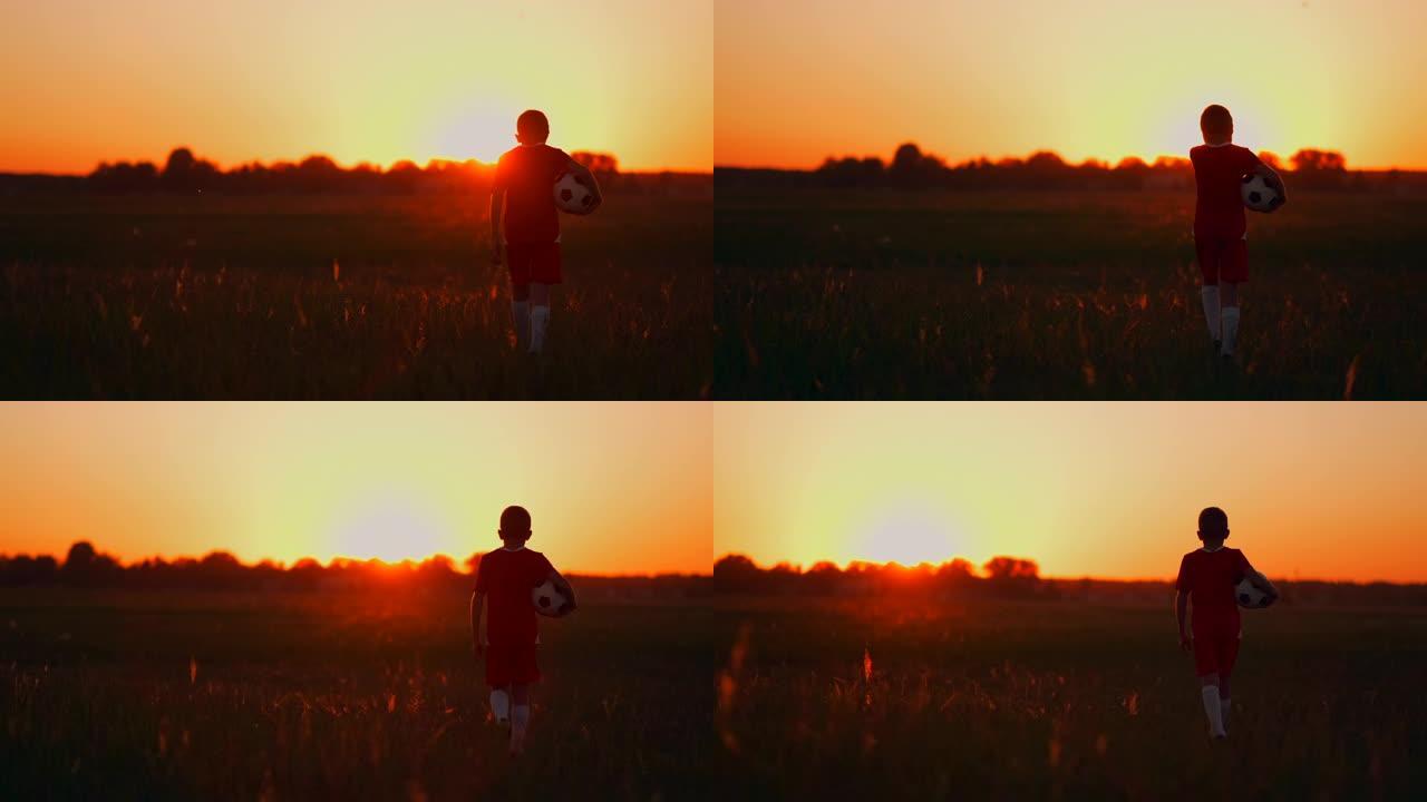 年轻的足球运动员在球场上梦想着足球生涯，在日落时看着太阳