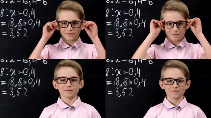 戴眼镜的男生看着相机，数学方程式写在黑板上