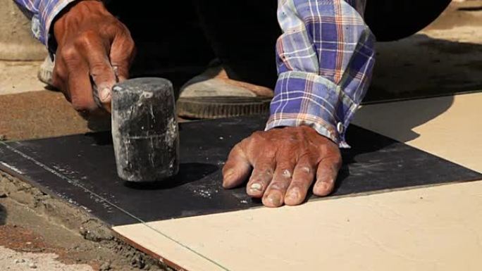慢动作，建筑工人使用锤子瓷砖地板