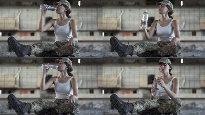 穿着军装的漂亮年轻女子从瓶子里喝水。