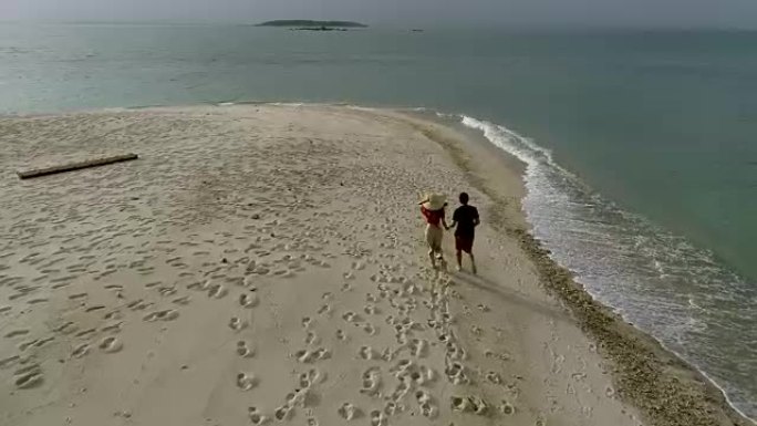 恋人在日落时分在沙滩上散步。
