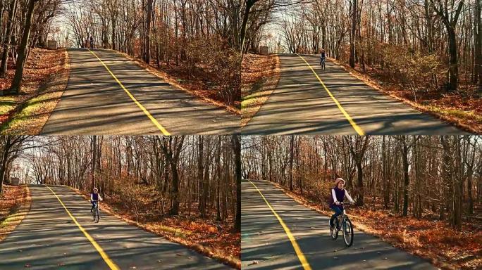 十几岁的女孩在秋天的森林里骑自行车在路上