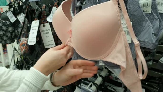 在购物中心购物的女人。选择内衣，胸罩。