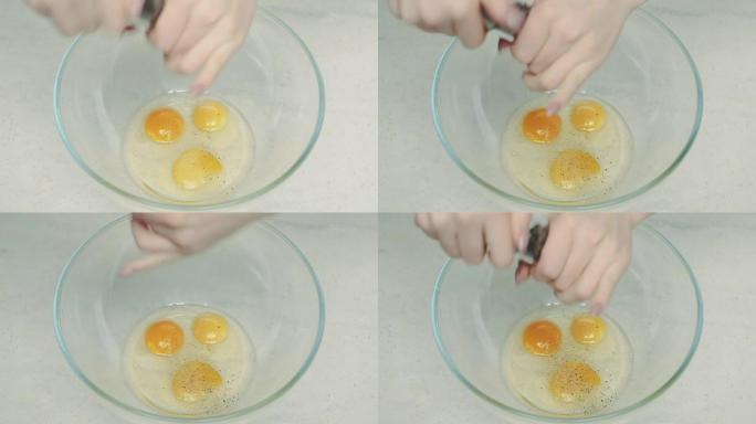 女人在碗中的蛋黄上撒黑胡椒