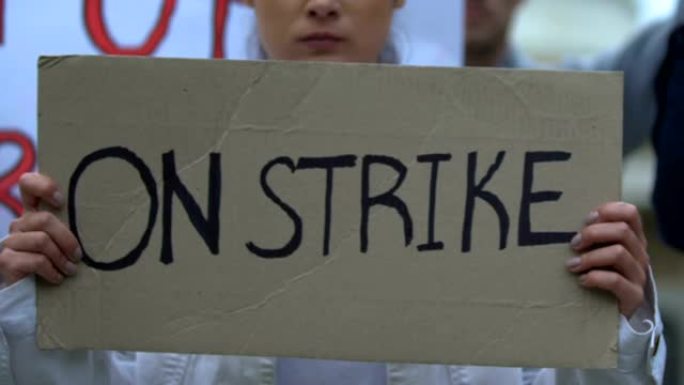 女职工举着写有“罢工，保护职工权益”的横幅