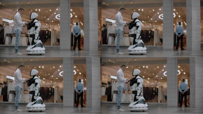 购物中心的那个人与机器人顾问交流。现代商店和机器人卖家。机器人在购物中心帮助一个人