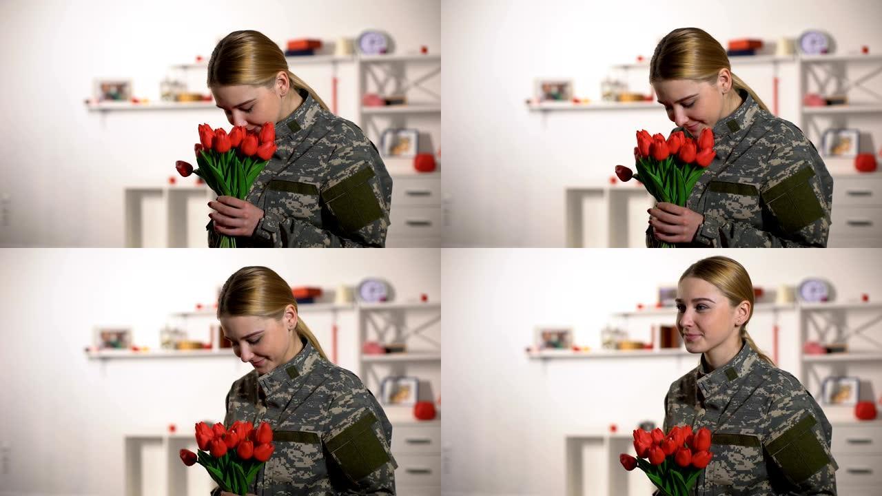 快乐的女军士欣喜的郁金香花束和微笑回家后的战争