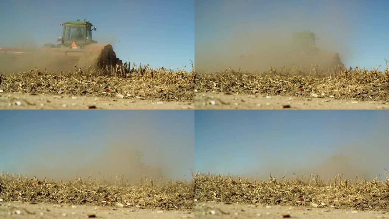 一辆带有排头的拖拉机在晴朗的蓝天下收获时在田间砍下玉米饲料