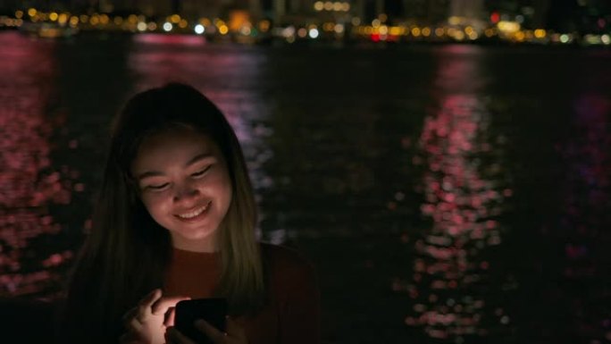 旅行者在晚上使用手机连接香港城市的网络。