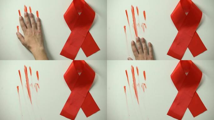 背景上的红丝带和男性手留下的血迹，艾滋病流行