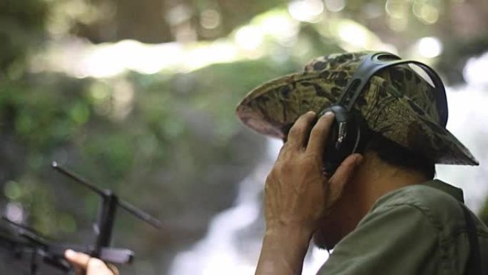研究人员收听来自无线电遥测的无线电信号，跟踪寻找热带雨林中的野生动物