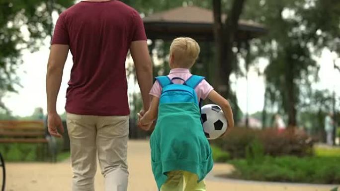 父亲放学后与儿子一起回家，讨论体育课，足球