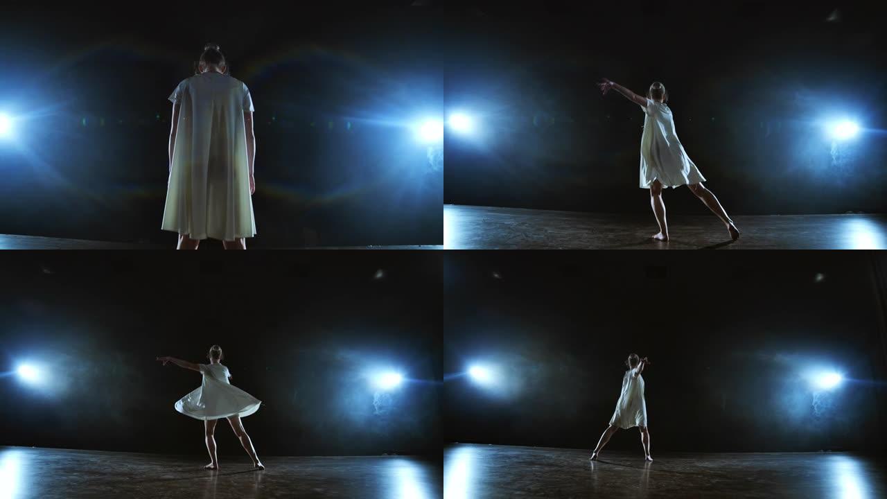 变焦镜头回来，一个穿着白色连衣裙的芭蕾舞女演员跳了起来，开始在聚光灯下在舞台上移动和奔跑，在白色背景