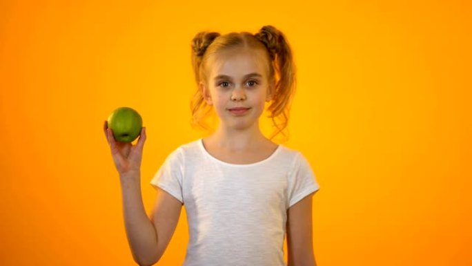可爱的少女展示新鲜的绿苹果，健康营养，有机食品