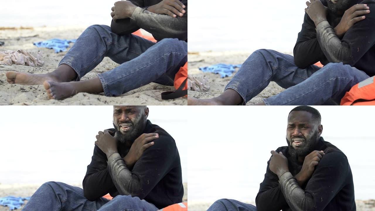 沮丧的非洲裔美国男性难民独自坐在居民岛海滩上