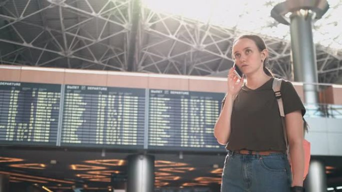 机场的一名妇女在电话中讨论他的航班延误