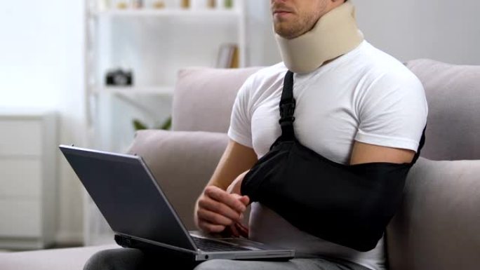 手提电脑手臂吊带颈圈的男子感到颈部疼痛，创伤