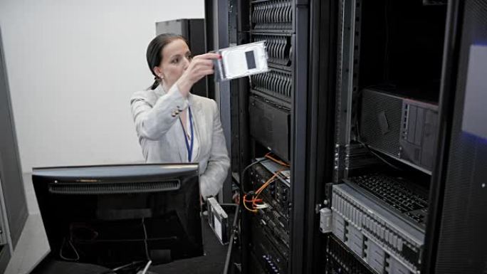 LD女IT工程师将硬盘插入服务器机架