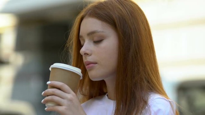 昏昏欲睡的年轻女子喝热咖啡感觉能量力量，早晨觉醒