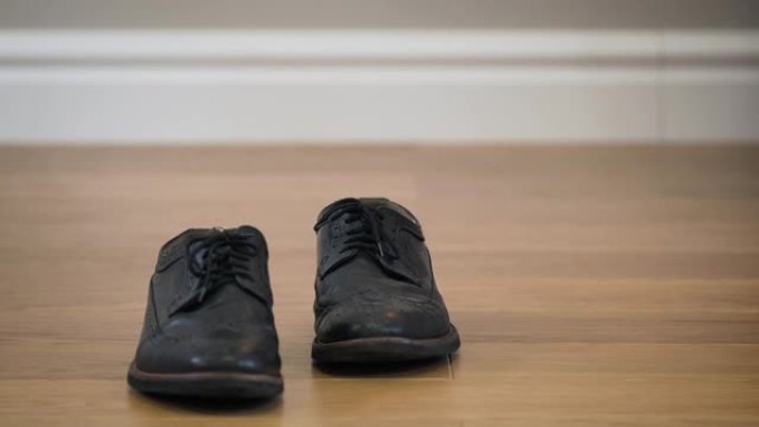 黑色时尚的broggi靴子站在木地板上。优雅皮鞋的特写镜头。时尚，时尚。