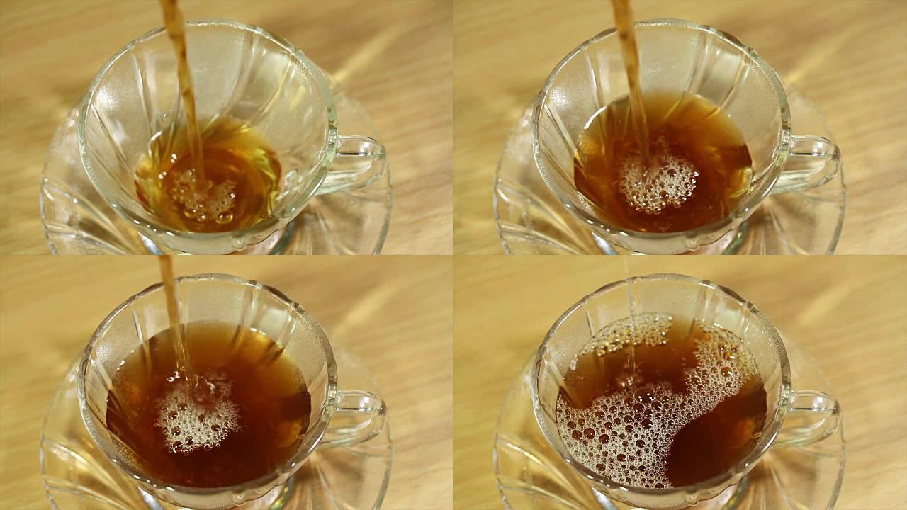 在带有绿色自然背景的玻璃茶杯中倒热茶，泰国早晨阳光普照