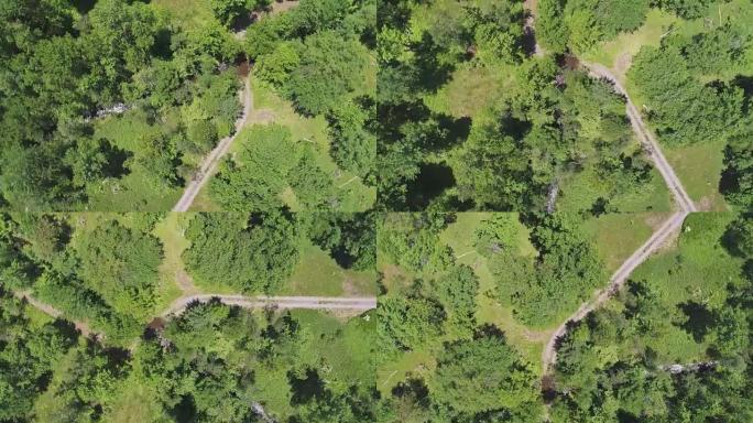 旋转。在夏季晴天，空中无人机可以直接看到乡村道路和波科诺山脉森林中的小河。
