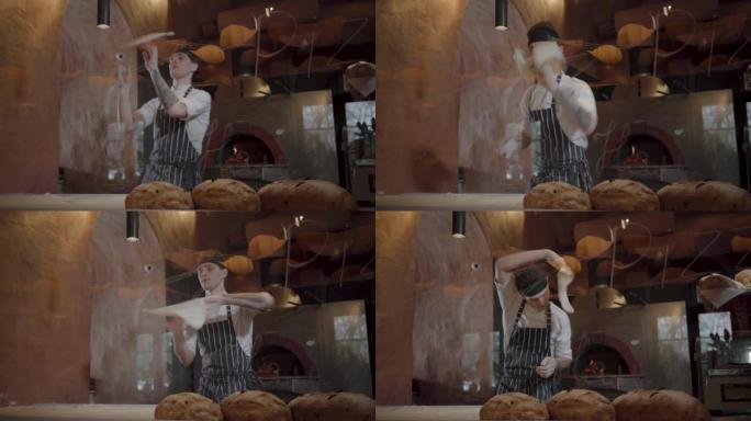 专业厨师在餐厅的厨房里旋转和扔披萨面团。
