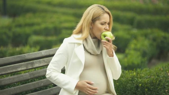 期待女人在吃苹果时感到恶心，晨吐，毒血症