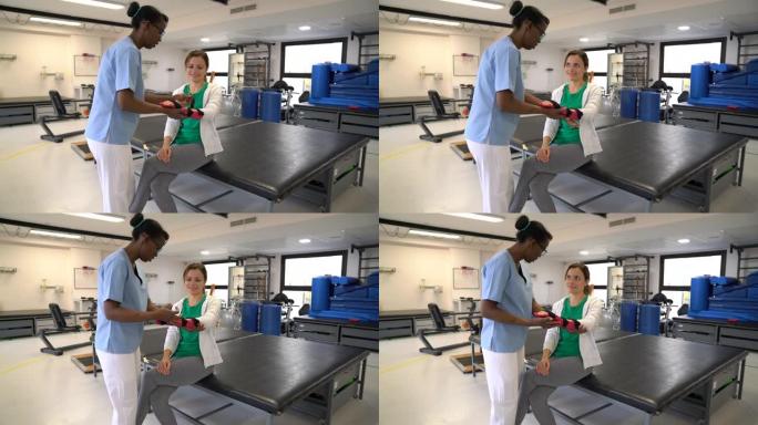 物理治疗师帮助女性患者在接受物理治疗后交谈时戴上手托